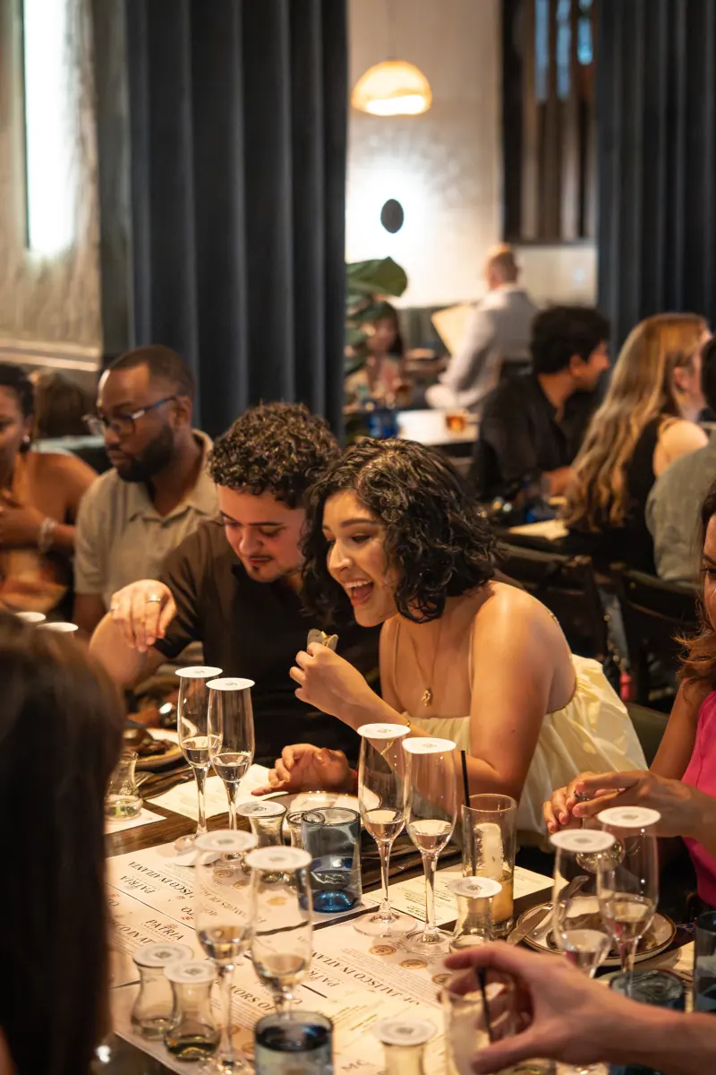 Guests sharing a laugh at a tasting dinner